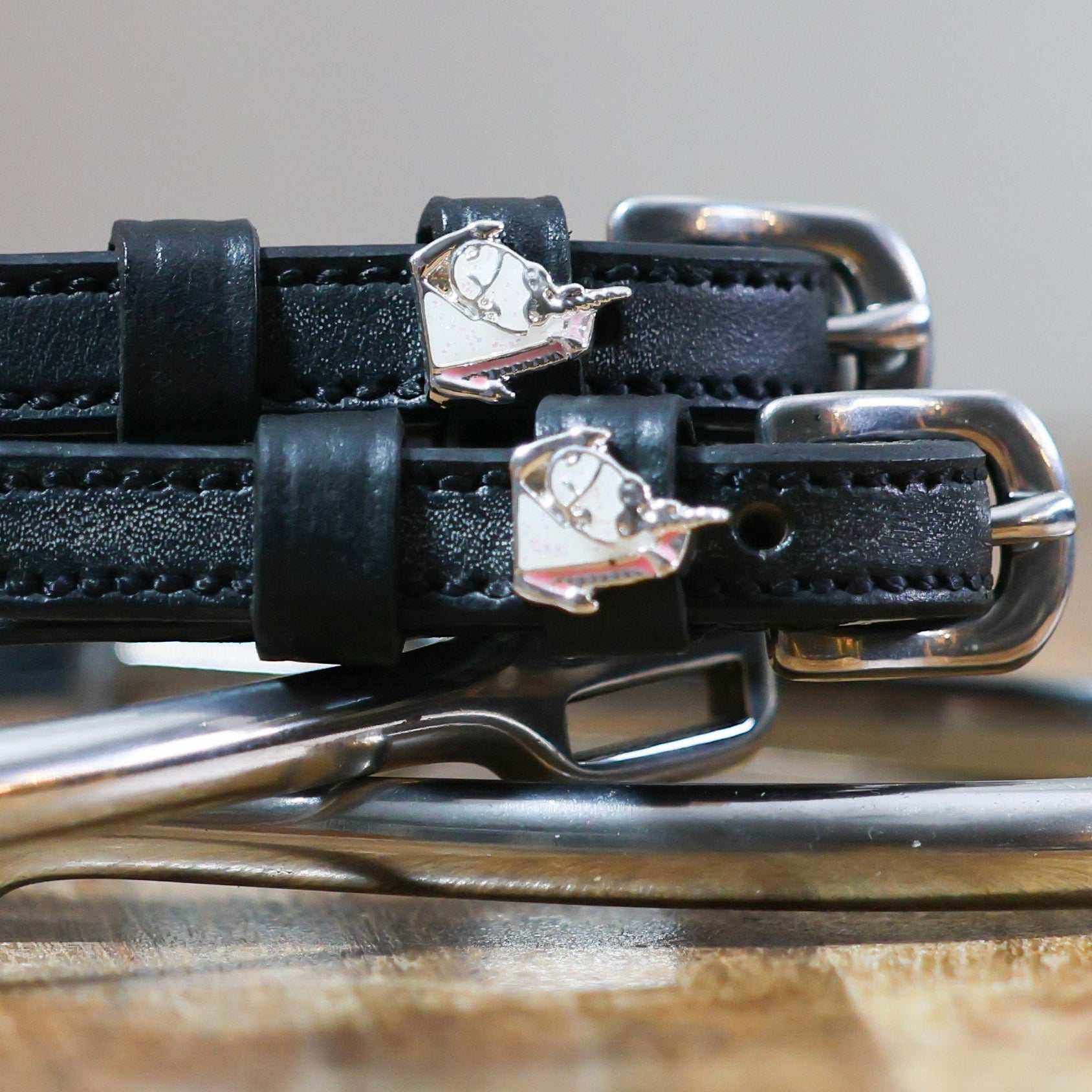 Close-up of black leather Sassy Unicorn Spur Straps with stainless steel buckles and custom unicorn charms