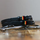 Black leather German Flag Spur Straps with stainless steel buckle and custom charm on peg wall display card