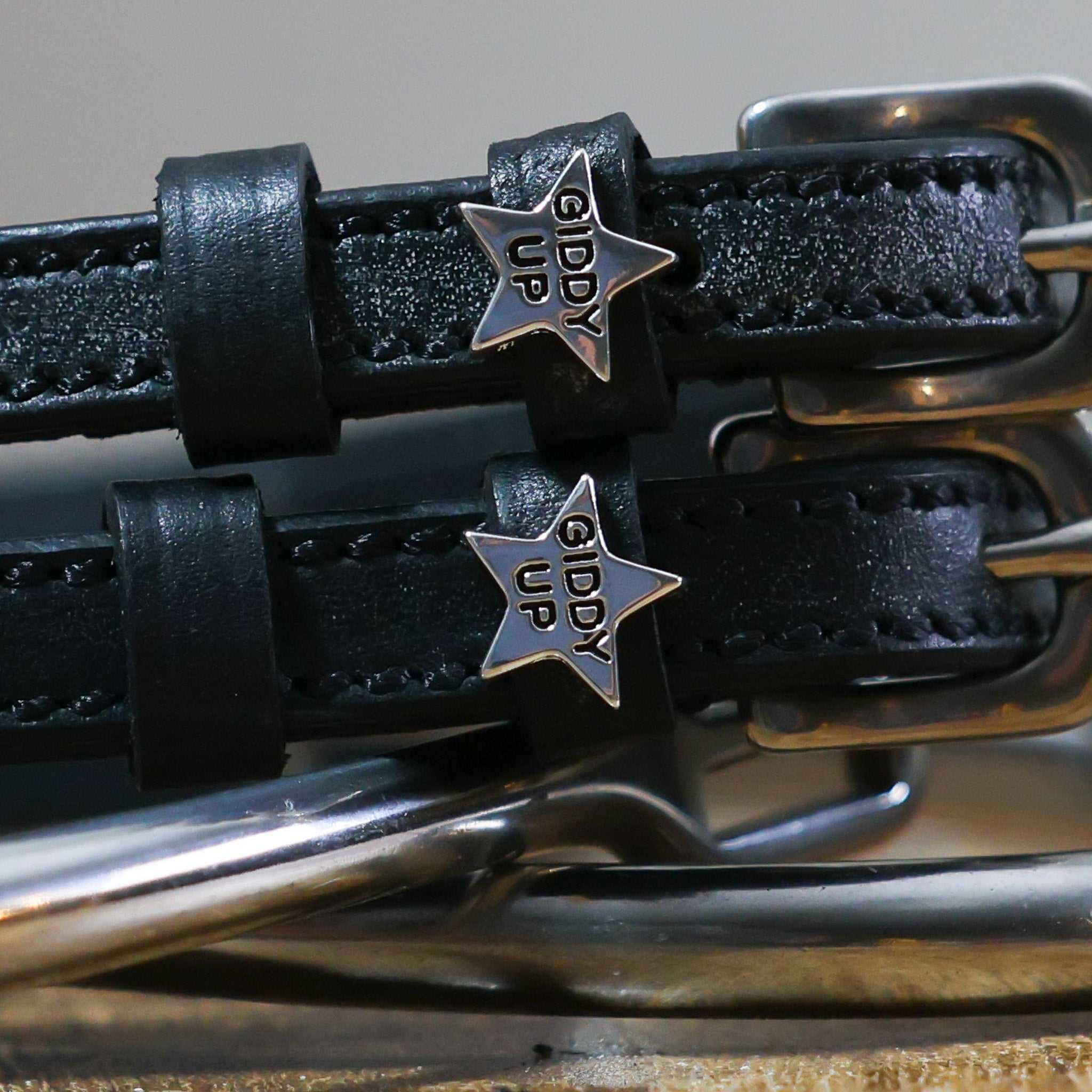 Giddy Up Spur Straps made of black leather with stainless steel buckles and star-shaped custom charms