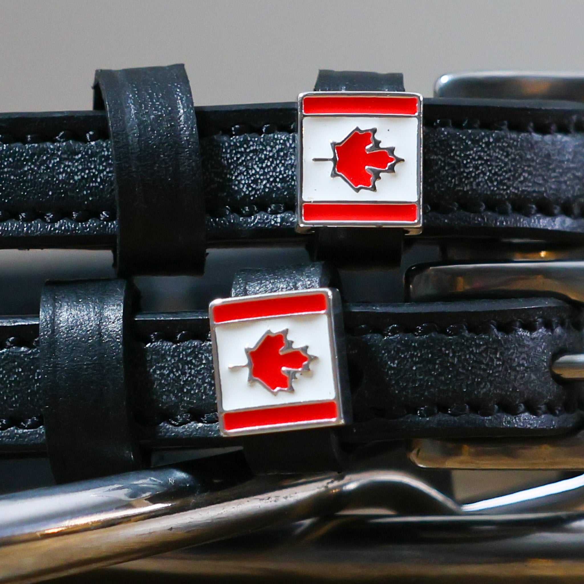 Black leather Canadian Flag Spur Straps with stainless steel buckles and custom maple leaf charms