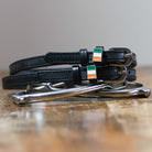 Black leather Irish spur straps with stainless steel buckle and custom charm displayed on peg wall cards