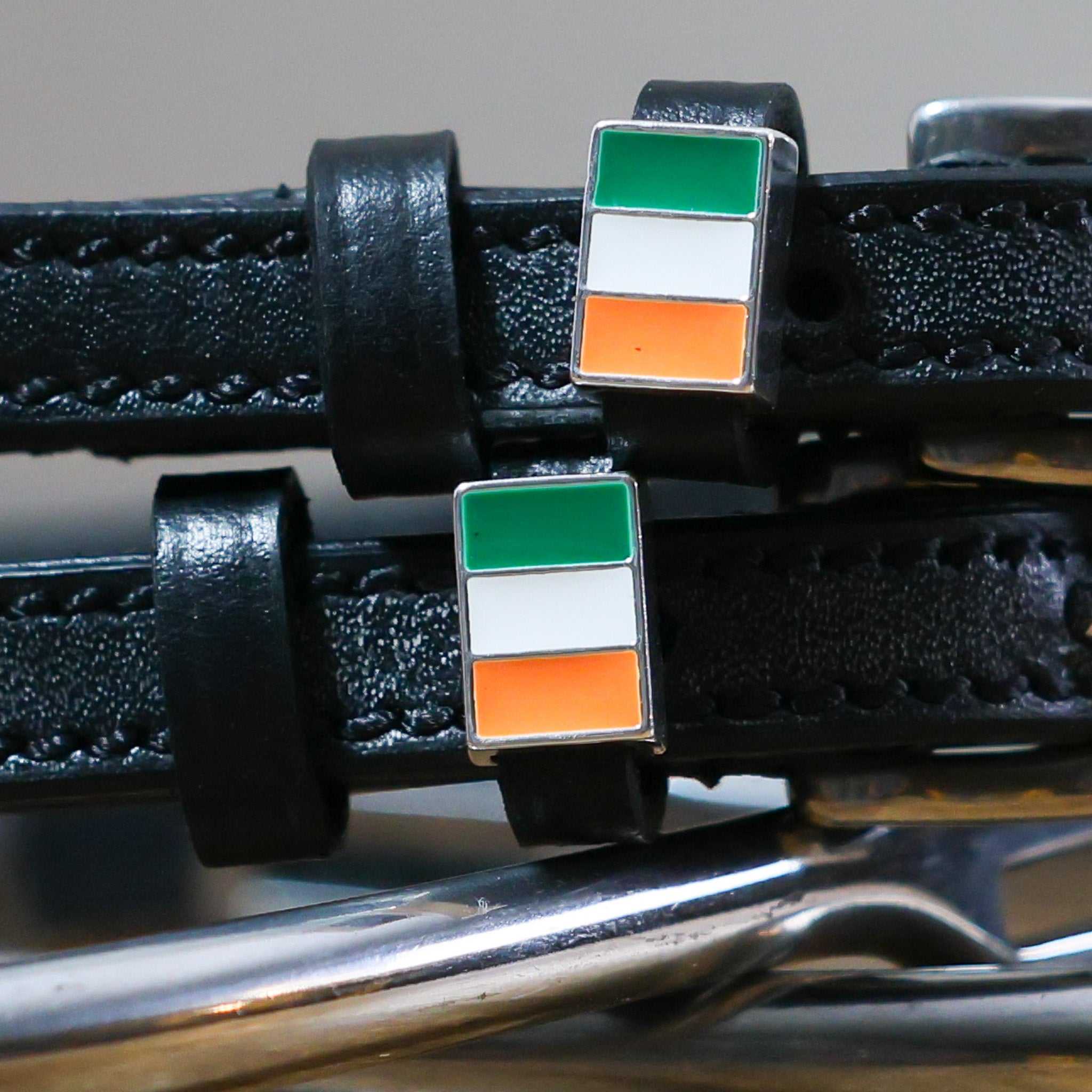 Black leather Irish Spur Straps with stainless steel buckle and Irish flag charm close-up