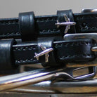 Close-up of black leather Plane Spur Straps with stainless steel buckle and airplane charm