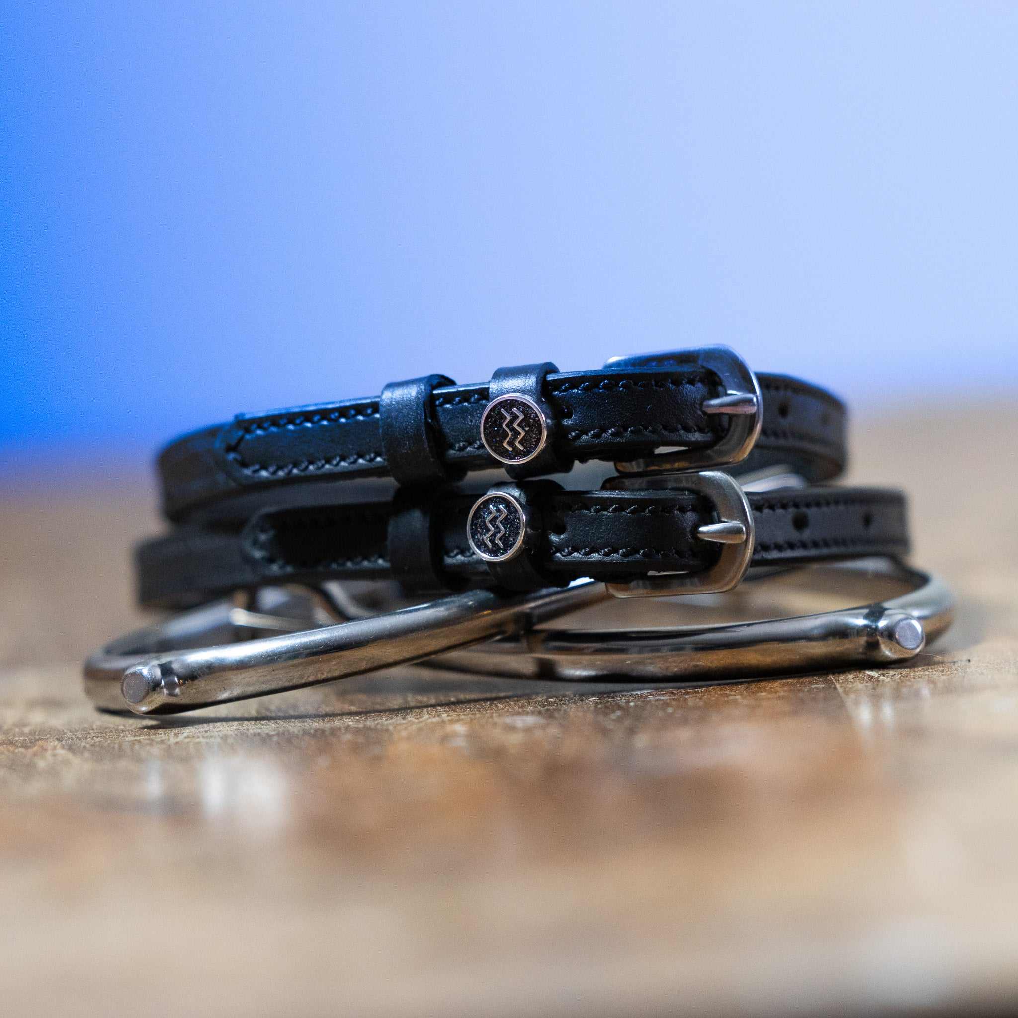 Black leather Aquarius Spur Straps with stainless steel buckles and custom ManeJane charms