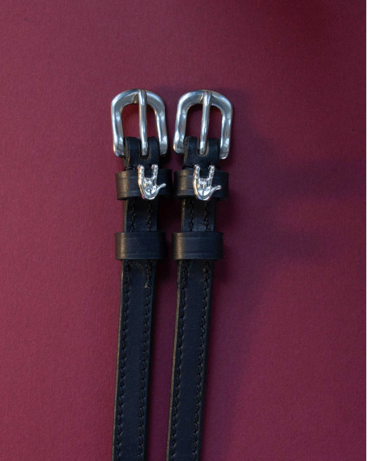 Rock On ManeJane spur straps with the signature Rock On charm, shown on a plum background
