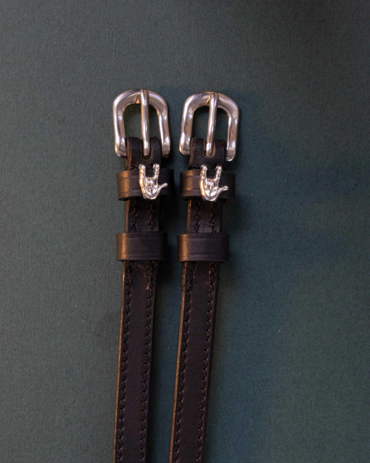 Rock On ManeJane spur straps with the signature Rock On charm, shown on a charcoal background