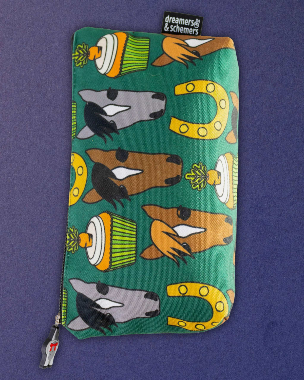 Carrot Cake zip pouch laid flat and upright, showing the full green print and the brand tag at the top