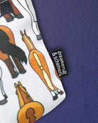 Detail of the Butts pouch print, a grey and a chestnut rear either side of the woven brand tag