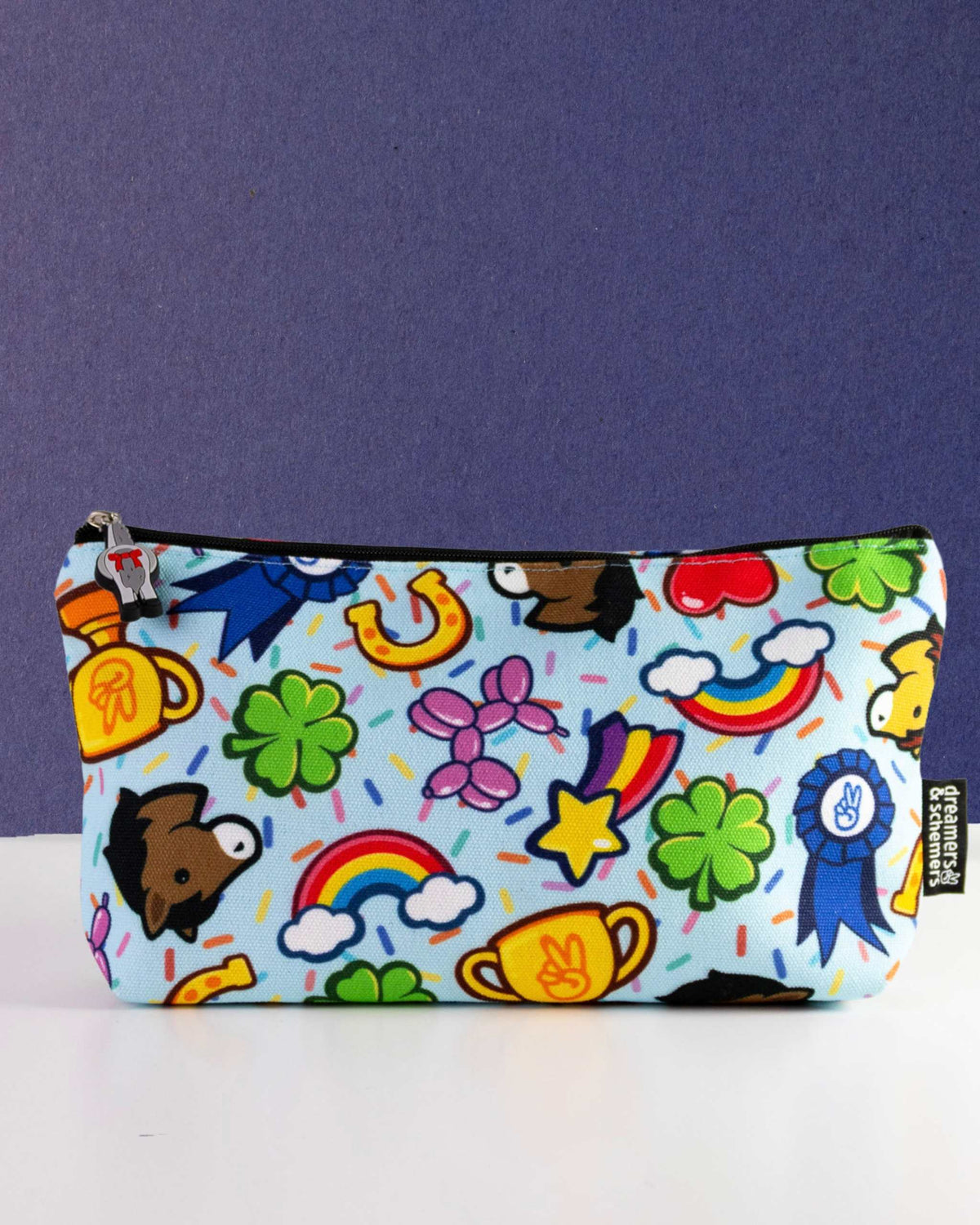 Lucky Charm zip pouch in pale blue, scattered with four-leaf clovers, rainbows and trophies, by Dreamers & Schemers