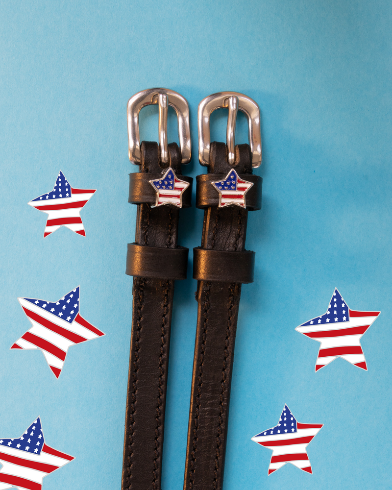 Brown leather ManeJane spur straps with silver buckles and American-flag star charms