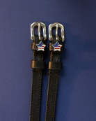 Brown leather American-flag star spur straps with silver buckles on indigo