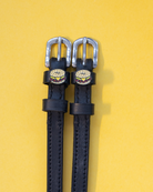 Black leather bagel sandwich spur straps on a yellow background