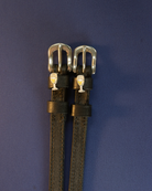 Pair of champagne-glass ManeJane spur straps flat on a navy background