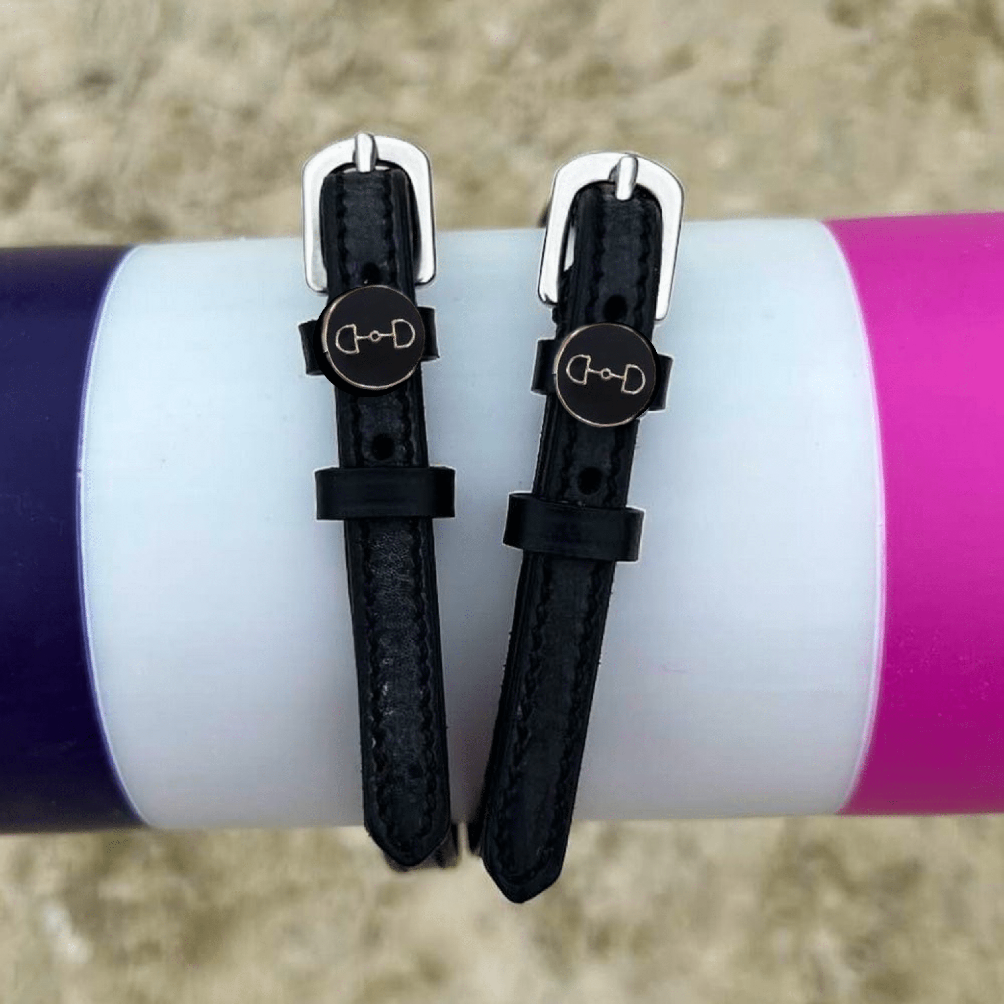 ManeJane D-ring spur straps wrapped around a white bottle outdoors