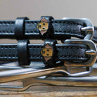 Close-up of tan Labrador dog face charms on black leather ManeJane spur straps
