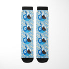 Custom socks featuring blue dreidel and chocolate gelt pattern on light blue background with black toe and cuff accents