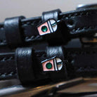 Close-up of iced coffee frappe cup charms on black leather spur strap keepers