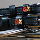Close-up of smiling French fry charms on black leather spur straps over spur hardware