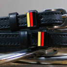 Close-up of black-red-gold German flag charms on black leather spur strap keepers