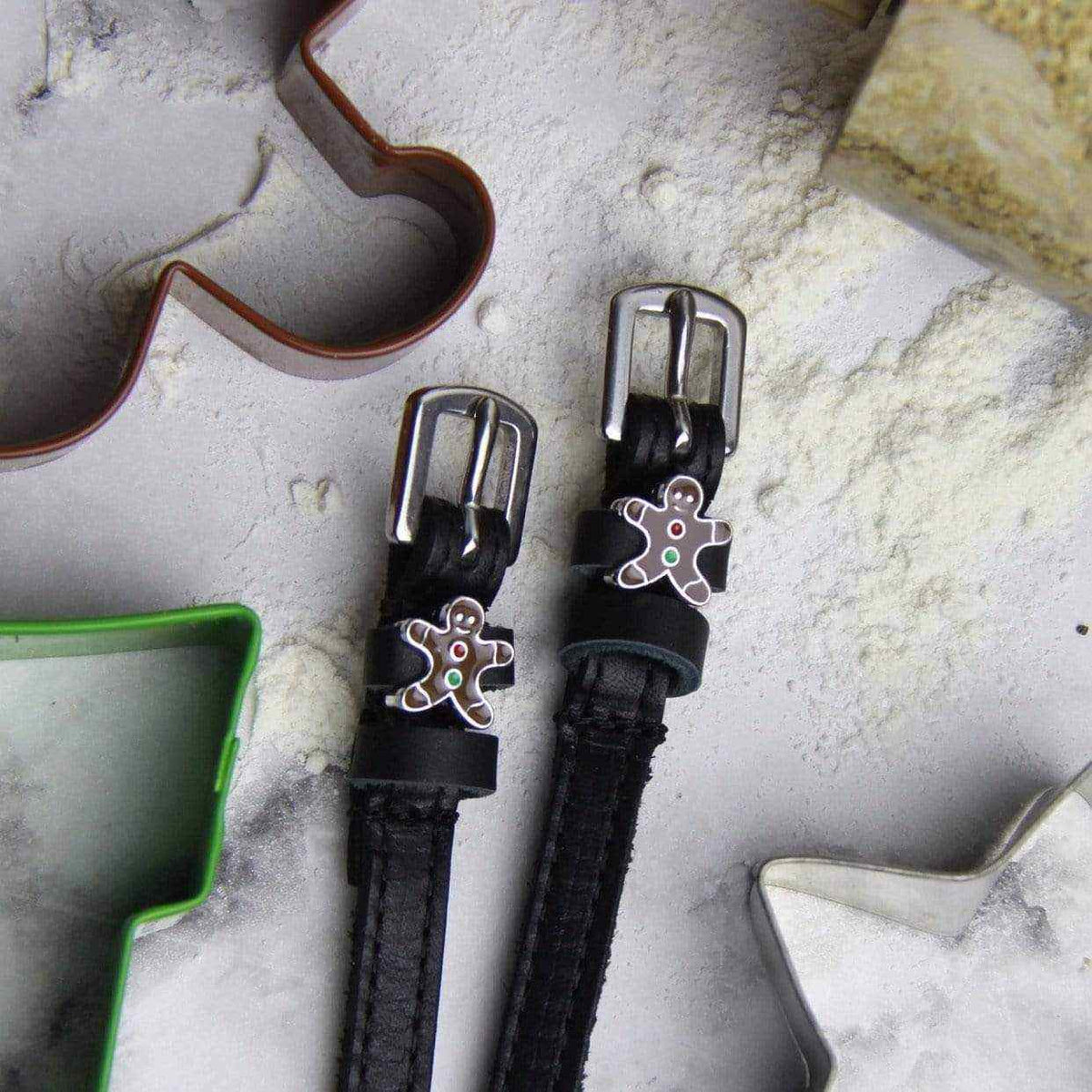 Gingerbread man spur straps on a floured board with festive cookie cutters