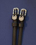 Black leather ManeJane spur straps with crystal horseshoe and clover charms on navy