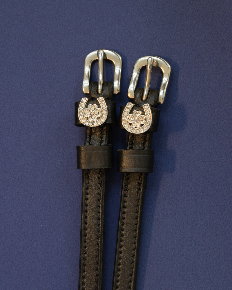 Black leather ManeJane spur straps with crystal horseshoe and clover charms on navy