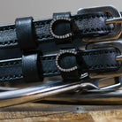 Close-up of rhinestone horseshoe charms on black leather ManeJane spur strap keepers