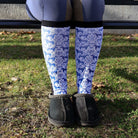 Limited Edition Pony Island Dala Horses Socks with blue folk-art pony design worn with black slippers outdoors