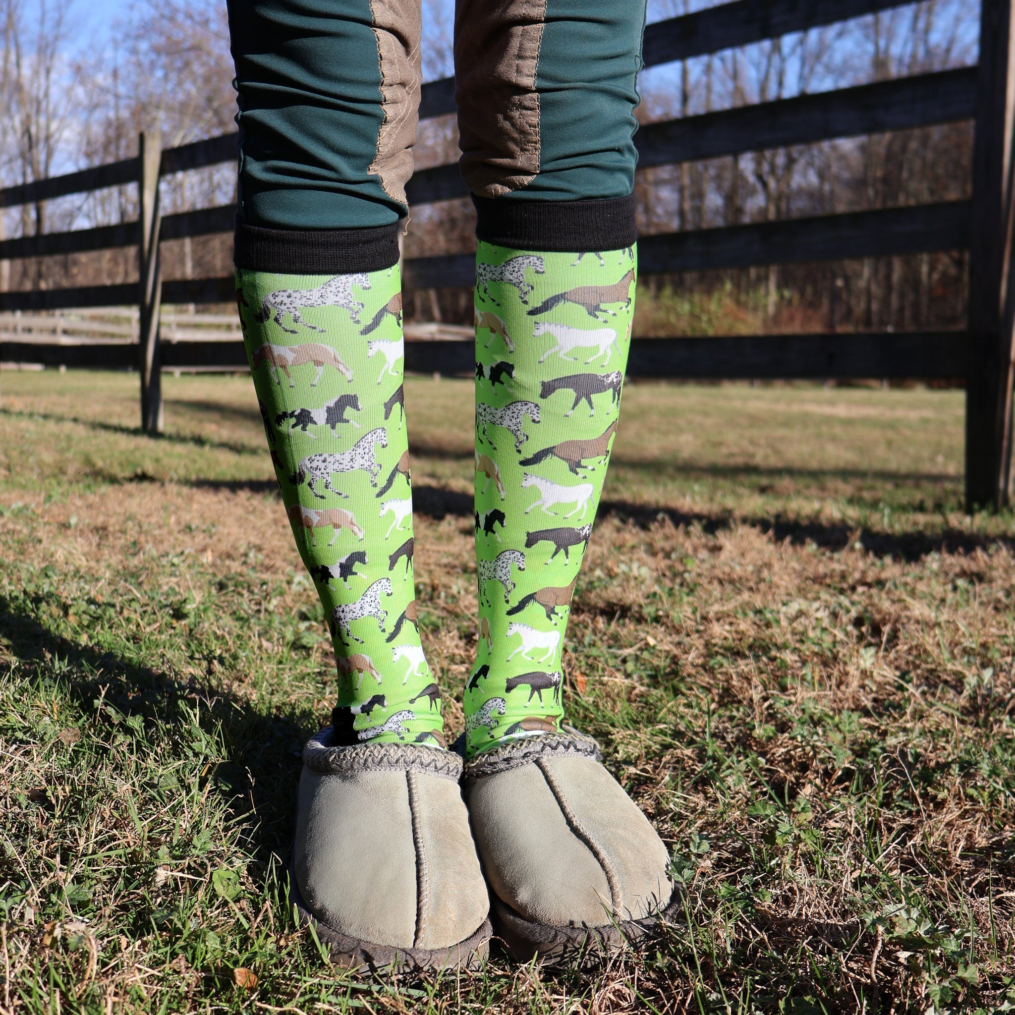 Limited edition neon green Pony Island boot socks with colorful pony patterns, worn outdoors with slippers