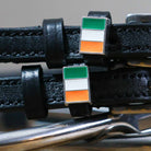 Close-up of Irish tricolor flag charms on black leather spur strap keepers