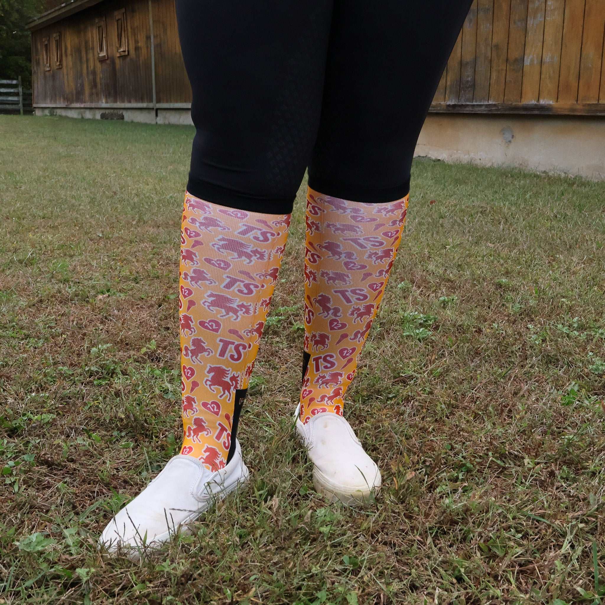 Limited edition Life of a Horse ShowGirl boot socks with colorful horse patterns, worn with black leggings and white shoes outdoors