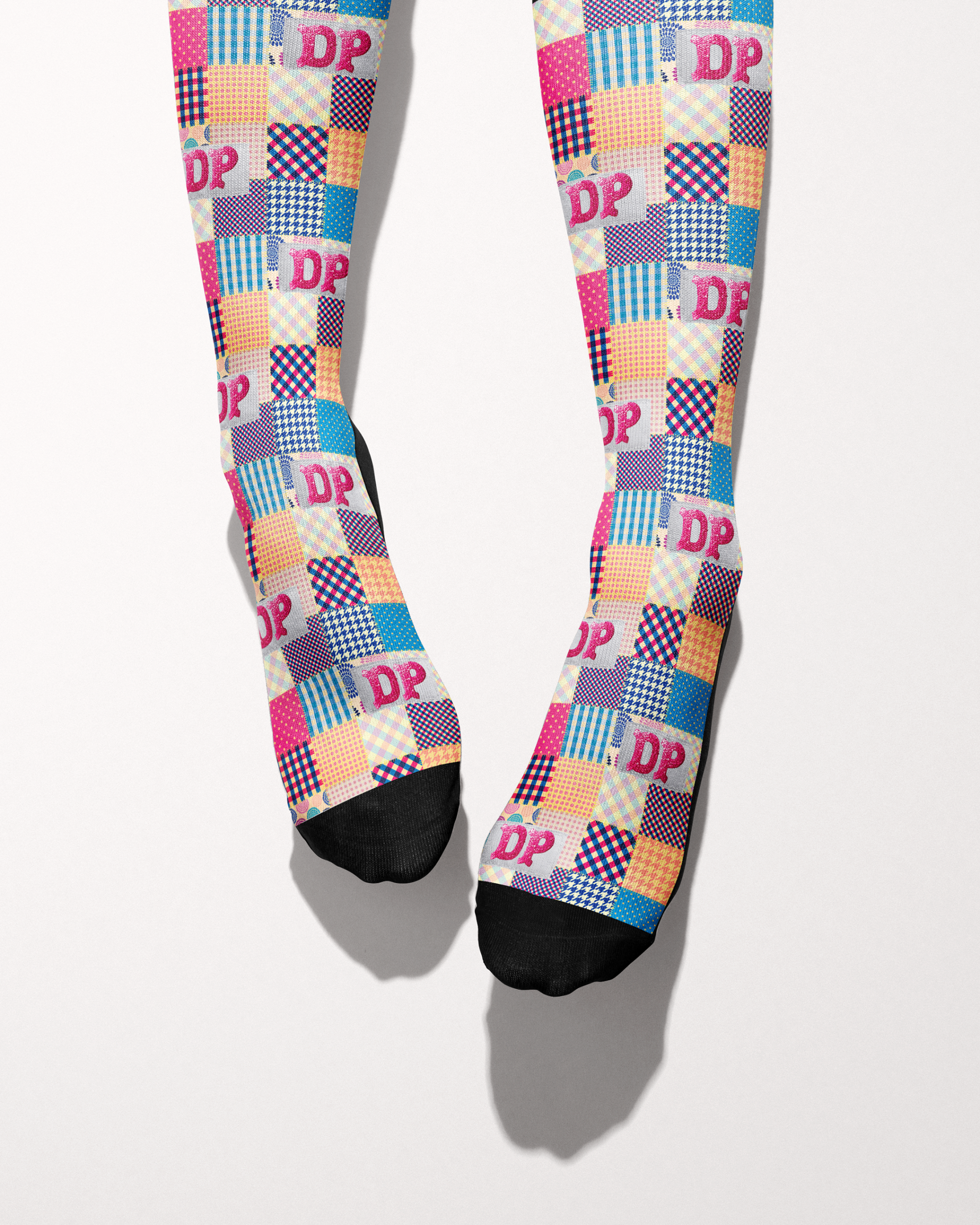 Socks of Many Colors socks shown on bare feet, black toes and heels against the patchwork print