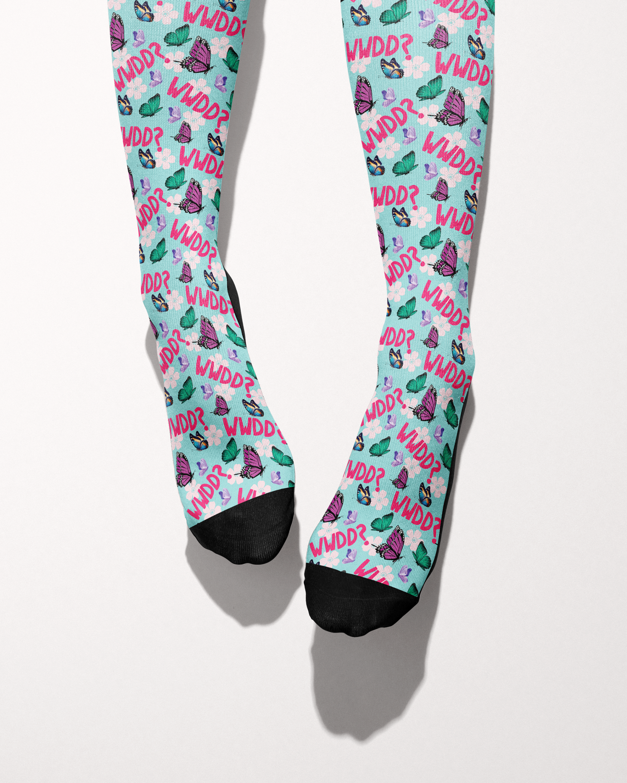 What Would Dolly Do? socks shown on bare feet with black toe and heel accents, mint green butterfly print