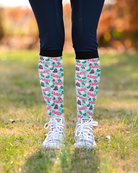 What Would Dolly Do? equestrian boot socks in mint green, shown pulled up over riding boots outdoors, by Dreamers & Schemers