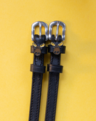 Black leather ManeJane spur straps with enamel moose head charms on yellow