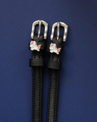 ManeJane chubby unicorn spur straps with silver buckles laid flat on navy blue
