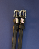 ManeJane pink dinosaur spur straps with silver buckles laid flat on navy blue