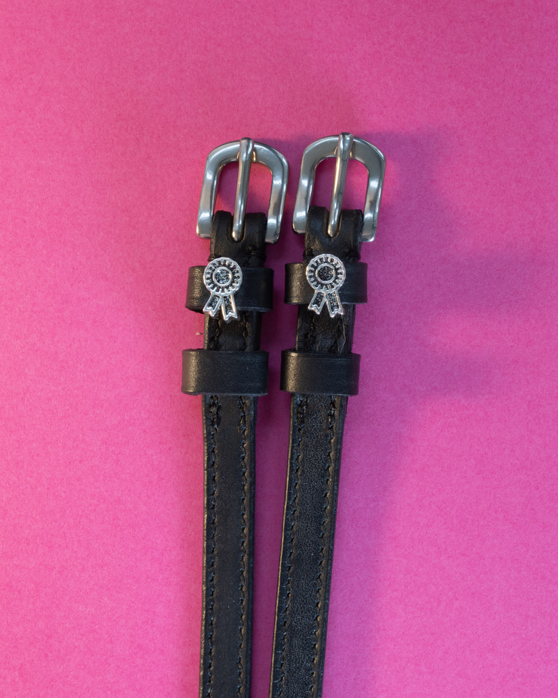 Black leather ManeJane spur straps with silver prize-rosette charms on magenta