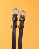 Brown leather ManeJane bolt charm spur straps with silver buckles on golden yellow