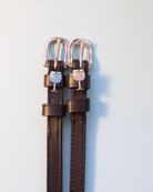Brown leather crystal wine glass spur straps with rose gold buckles on pale grey