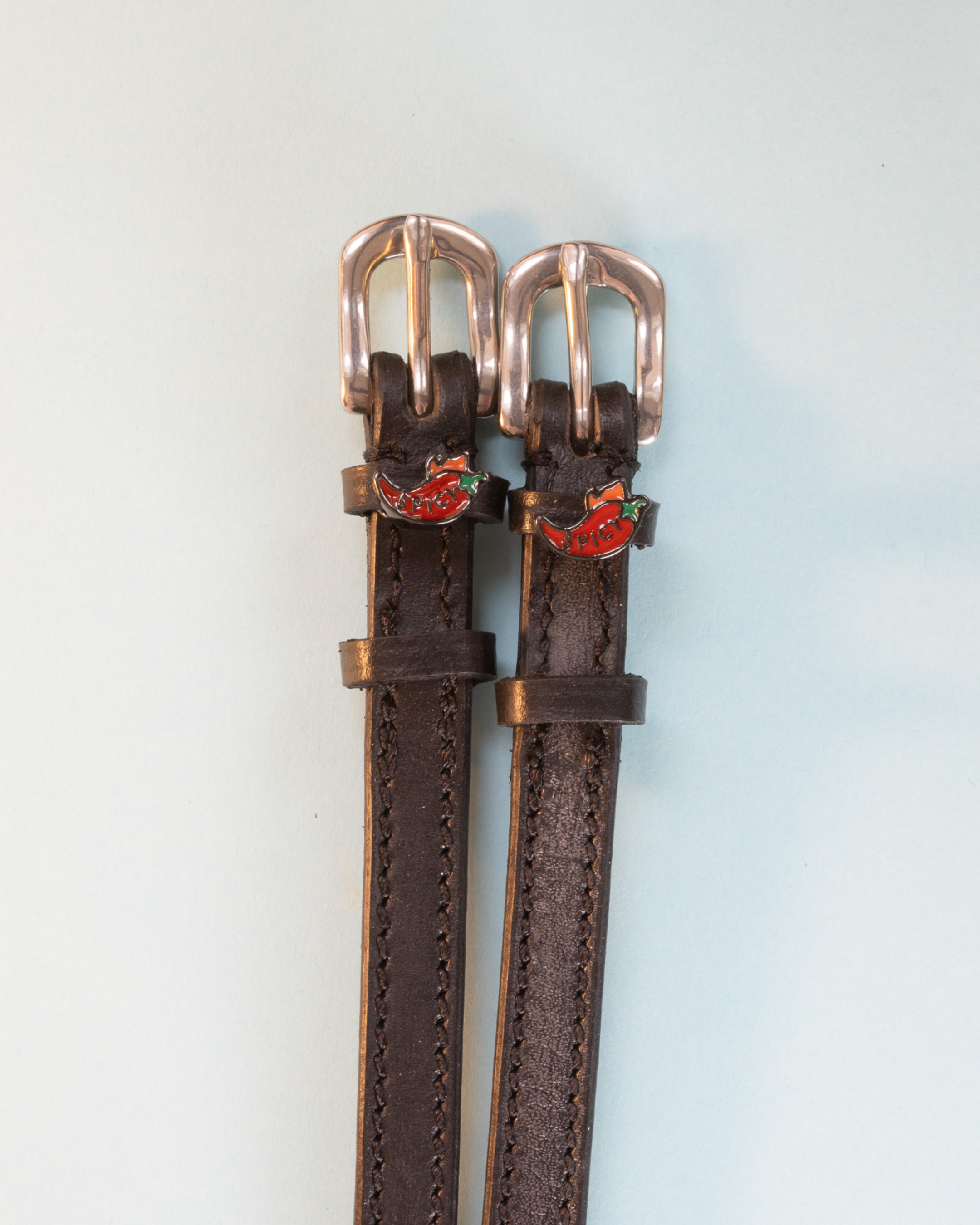 Brown leather ManeJane spicy pepper spur straps with rose-gold buckles and red chili charms