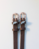 Brown leather ManeJane stingray spur straps with blue ray charms and rose-gold buckles