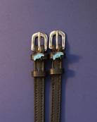 Black leather stingray spur straps with blue stingray charms on an indigo background, ManeJane