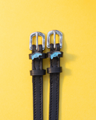 ManeJane stingray spur straps with blue stingray charms on a bright yellow background