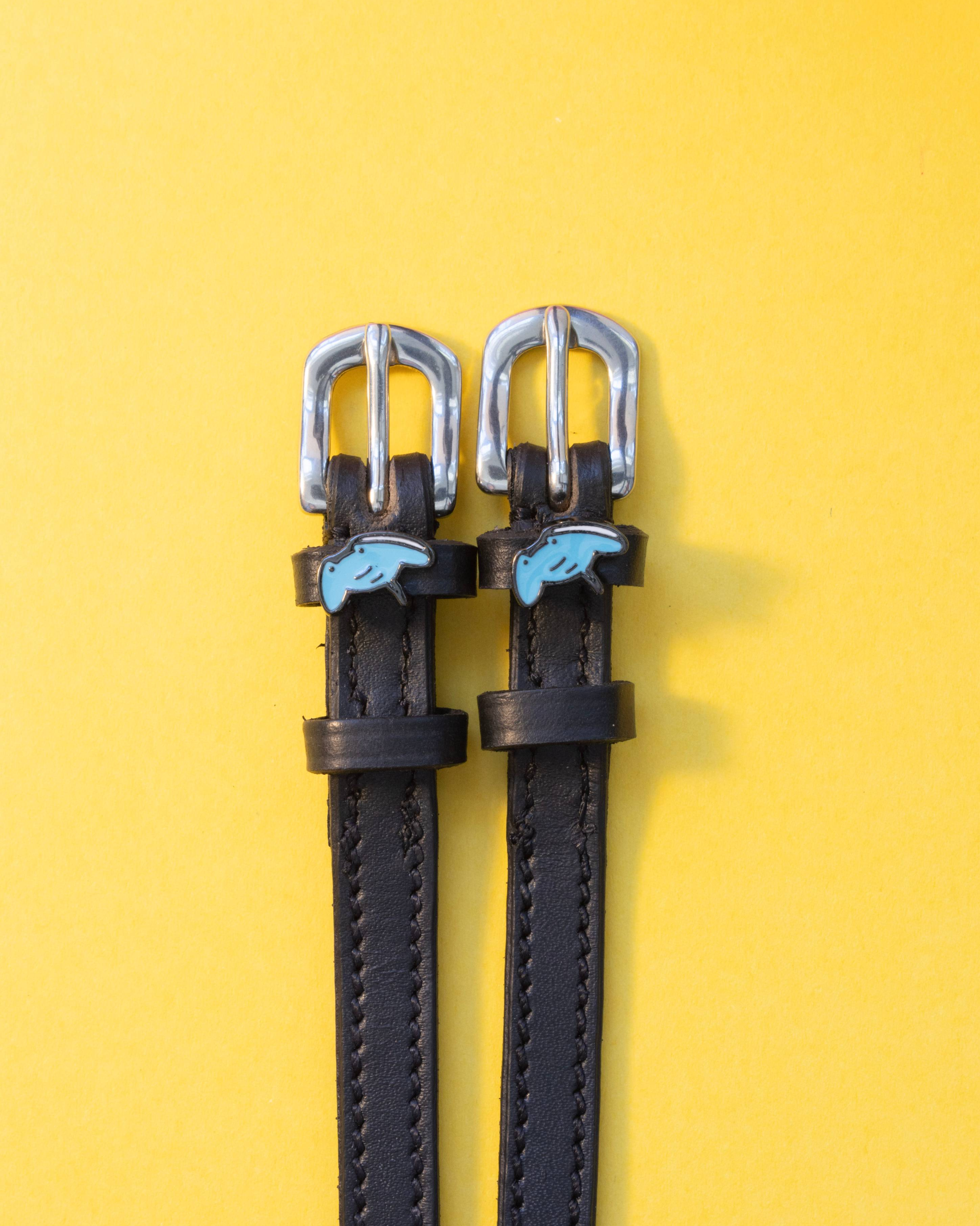 ManeJane stingray spur straps with blue stingray charms on a bright yellow background