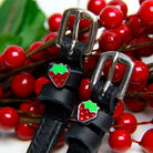Strawberry spur straps with silver buckles among red berries and green leaves, ManeJane