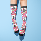 Custom flower socks with smiley faces and rooster design on pink background worn on legs