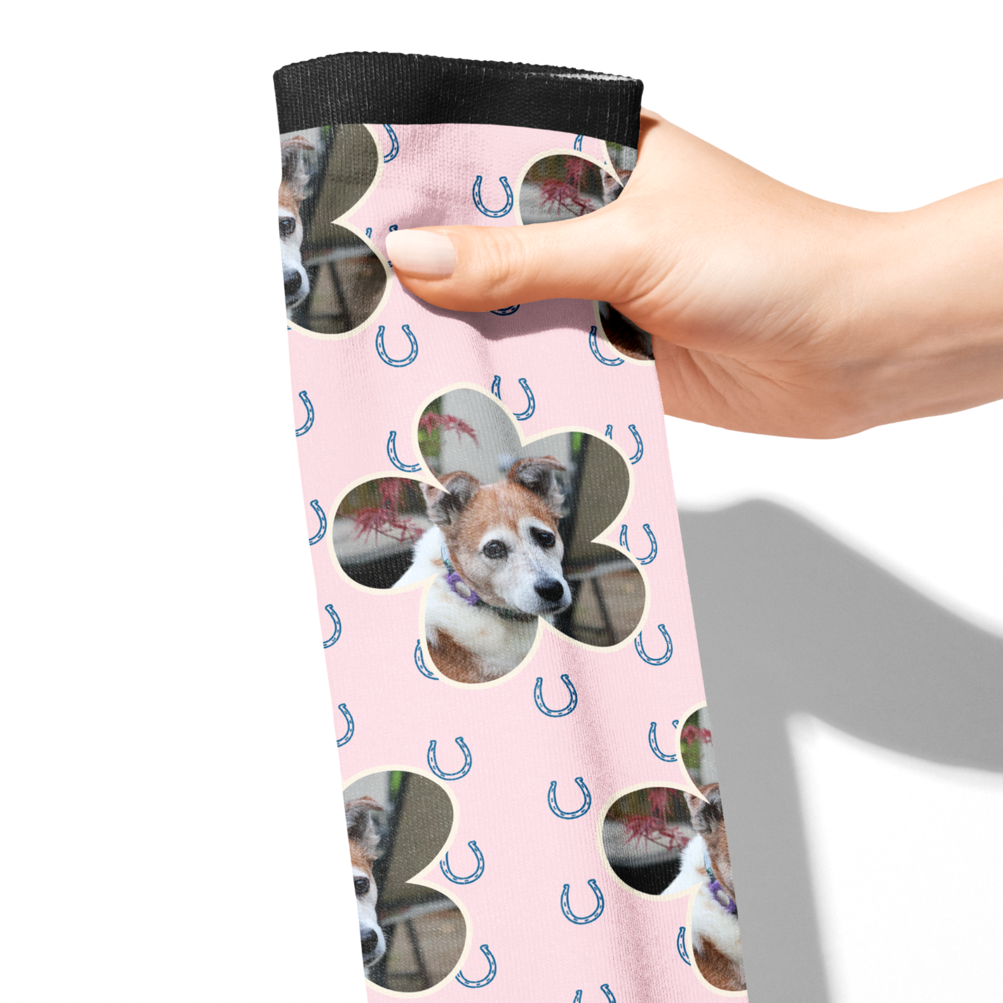 Custom flower socks with blue horseshoes and personalized dog photo on pink background held in hand