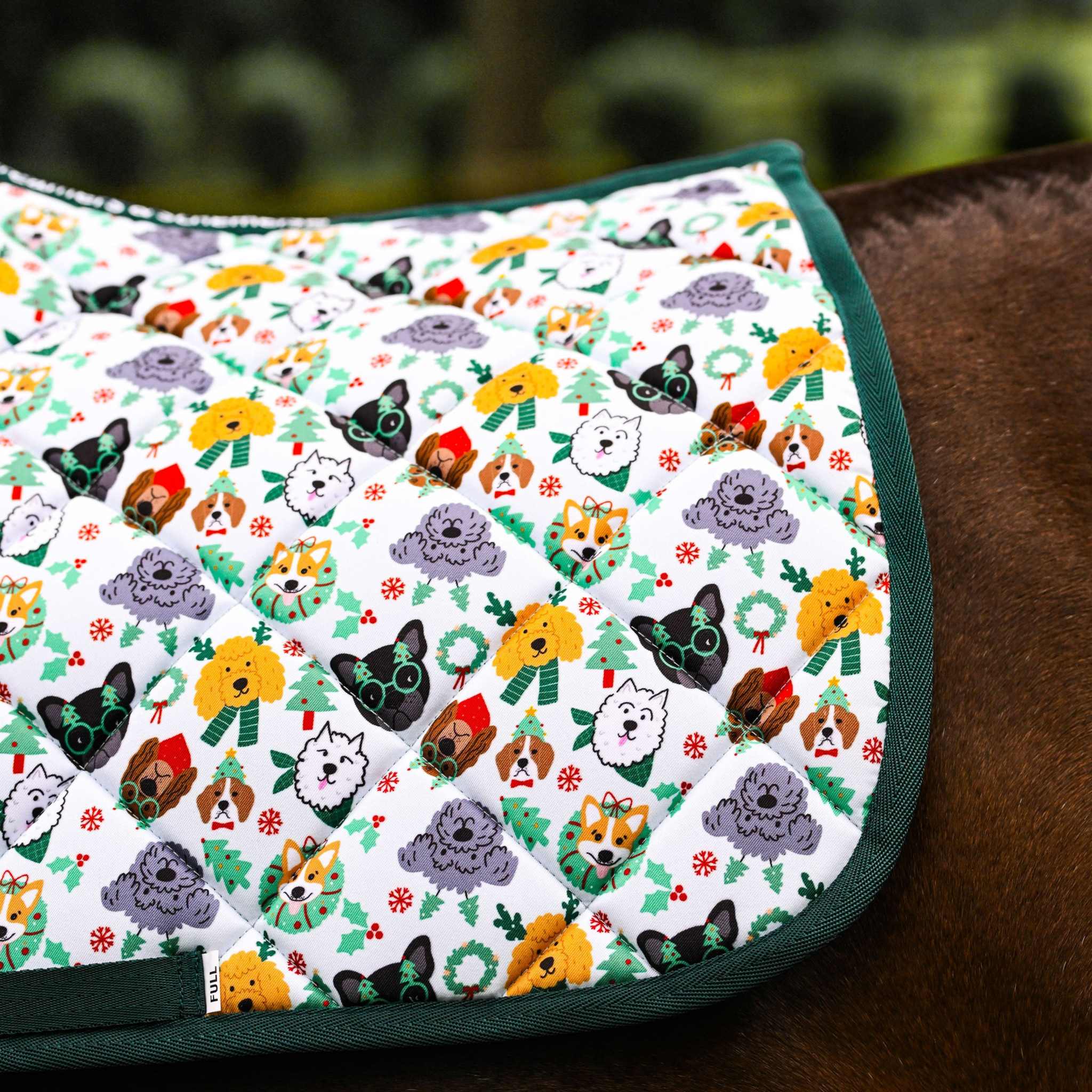 Deck the Paws Saddle Pad with playful dog pattern and green trim on horse saddle.