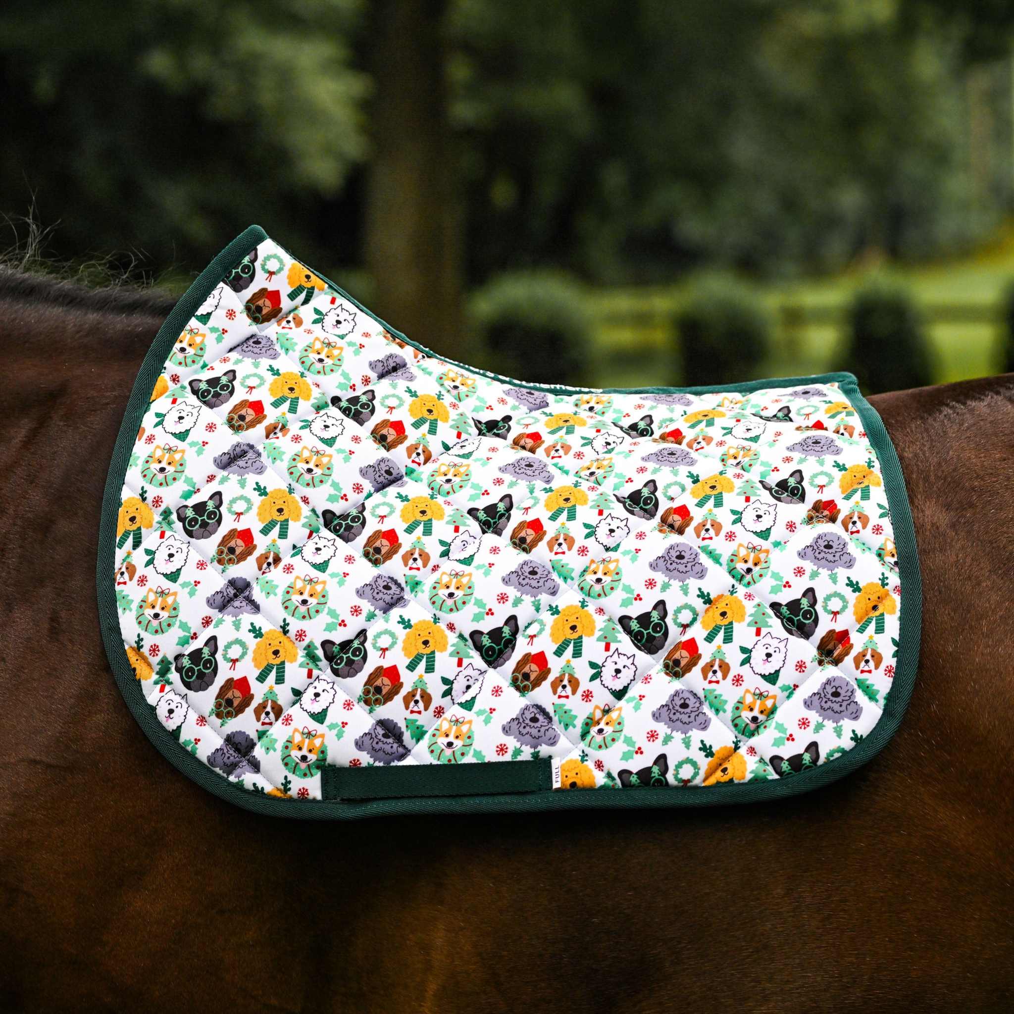 Deck the Paws Saddle Pad with colorful dog pattern and green trim on horse back, cushy quilting for comfortable everyday riding